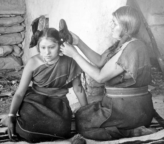 Женщина хопи поправляет волосы незамужней девушке, 1900 год.