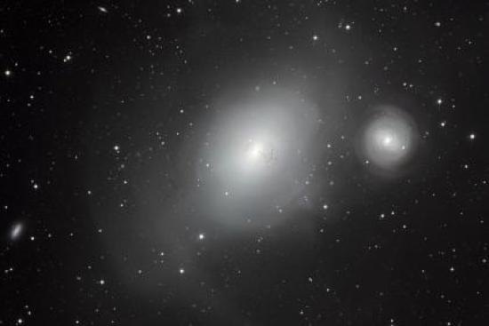NGC 1316 (слева) и поглощаемая ею NGC...
